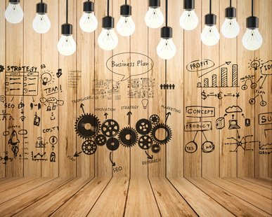 Creative workspace with business strategy sketches and hanging light bulbs